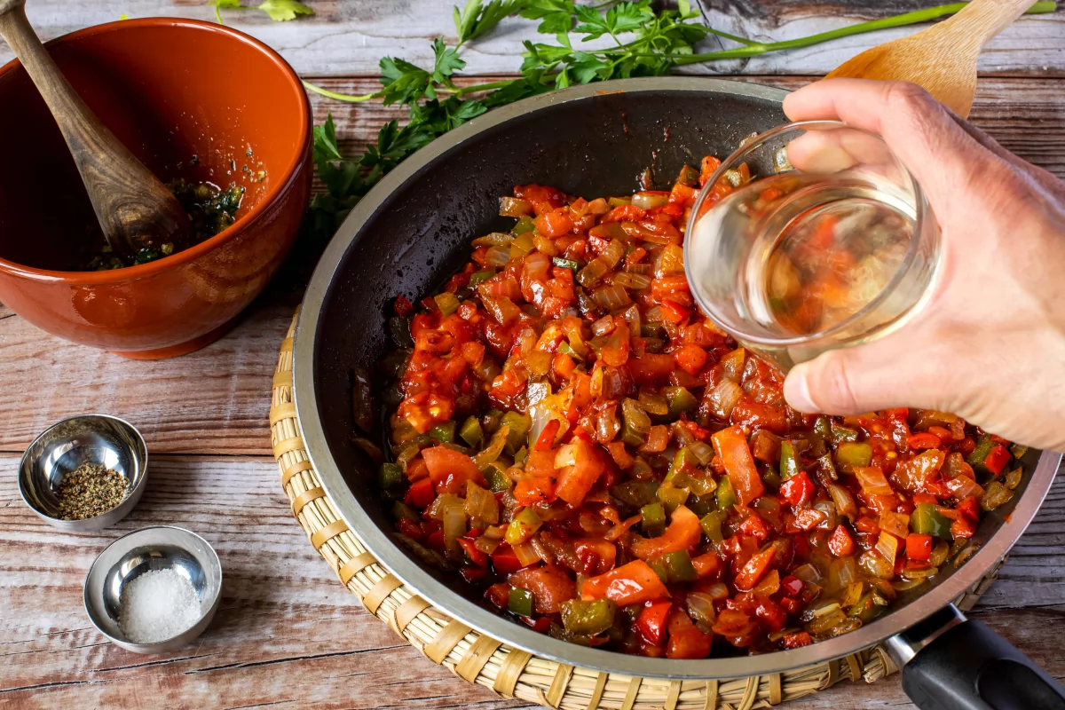 Incorporar el vino blanco al sofrito de la salsa de las albóndigas y dejar evaporar el alcohol