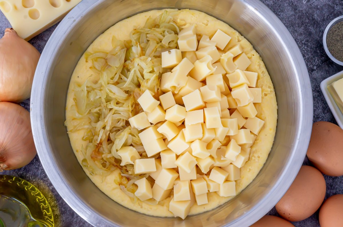 Incorporar la cebolla y el queso a la sopa paraguaya