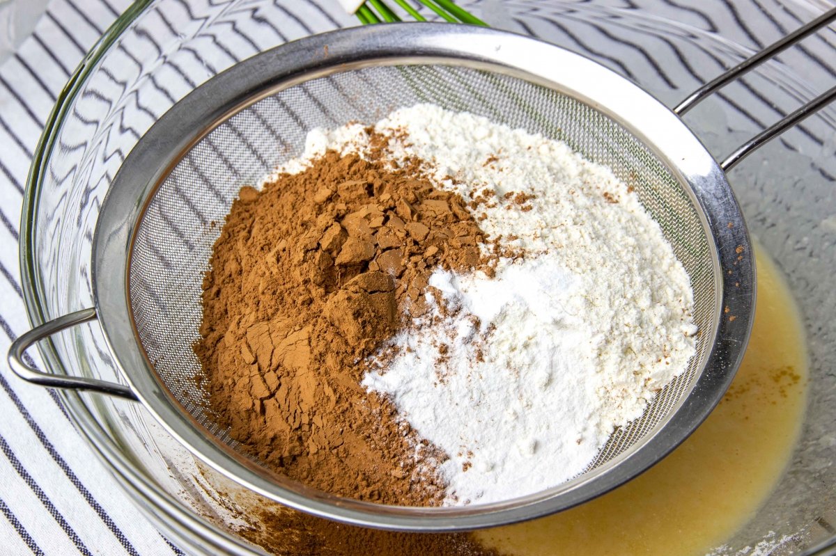 Incorporar la harina, el cacao, el impulsor y la sal para mezclar la masa del bizcocho de la tarta