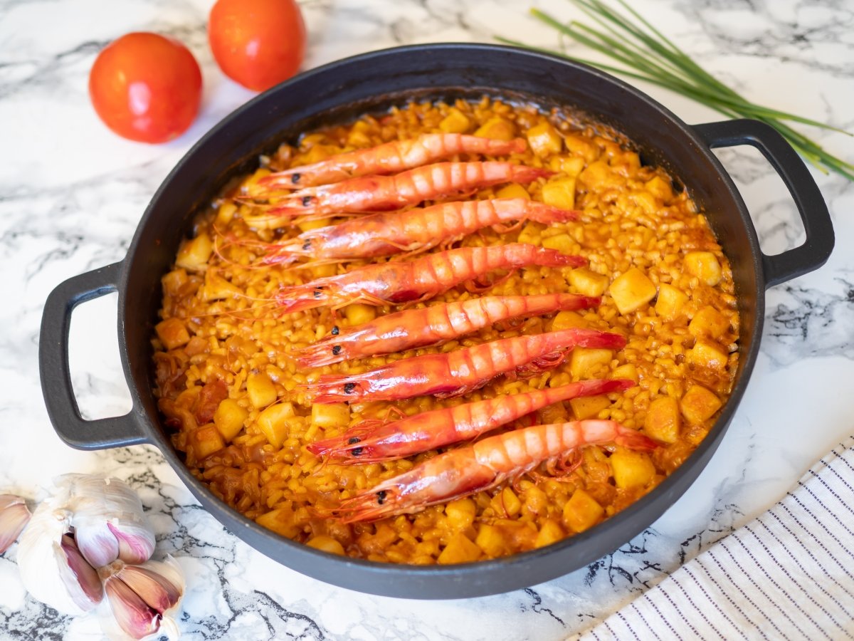 Incorporar las gambas para el arroz con sepia y gambas