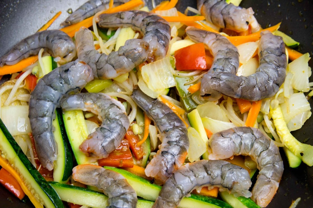 Incorporar los langostinos y el caldo concentrado a las verduras