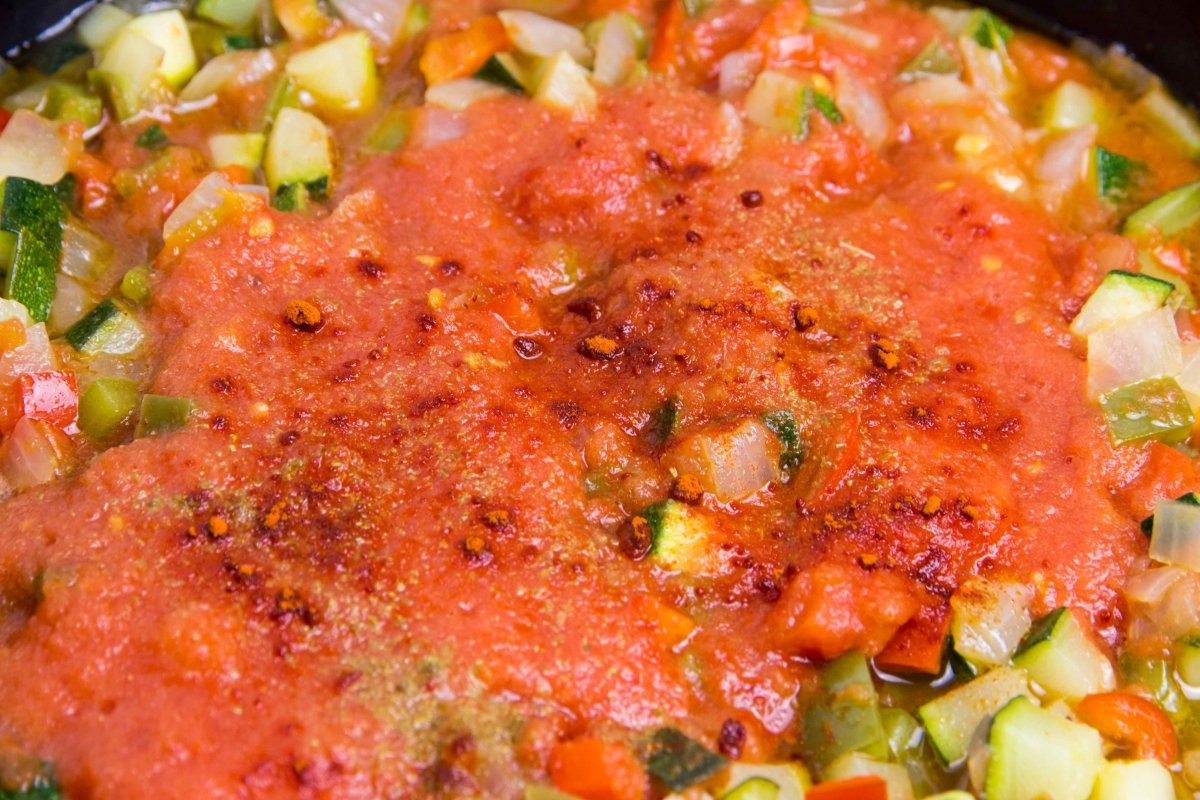 Incorporar los tomates triturados y especias para hacer el pisto manchego