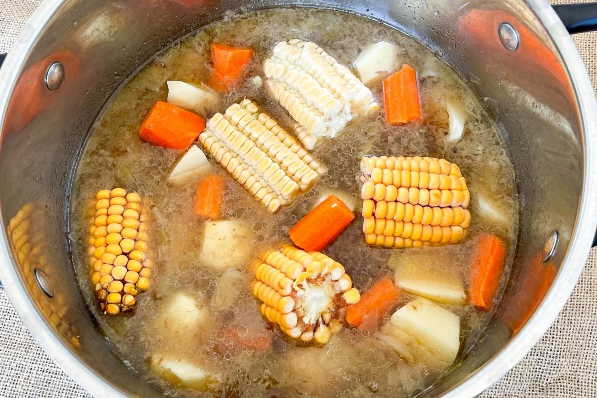 Incorporar maíz, patatas y zanahorias a la cocción
