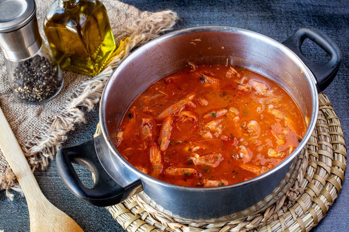 Incorporar tomate, hierbas y caldo para la salsa americana