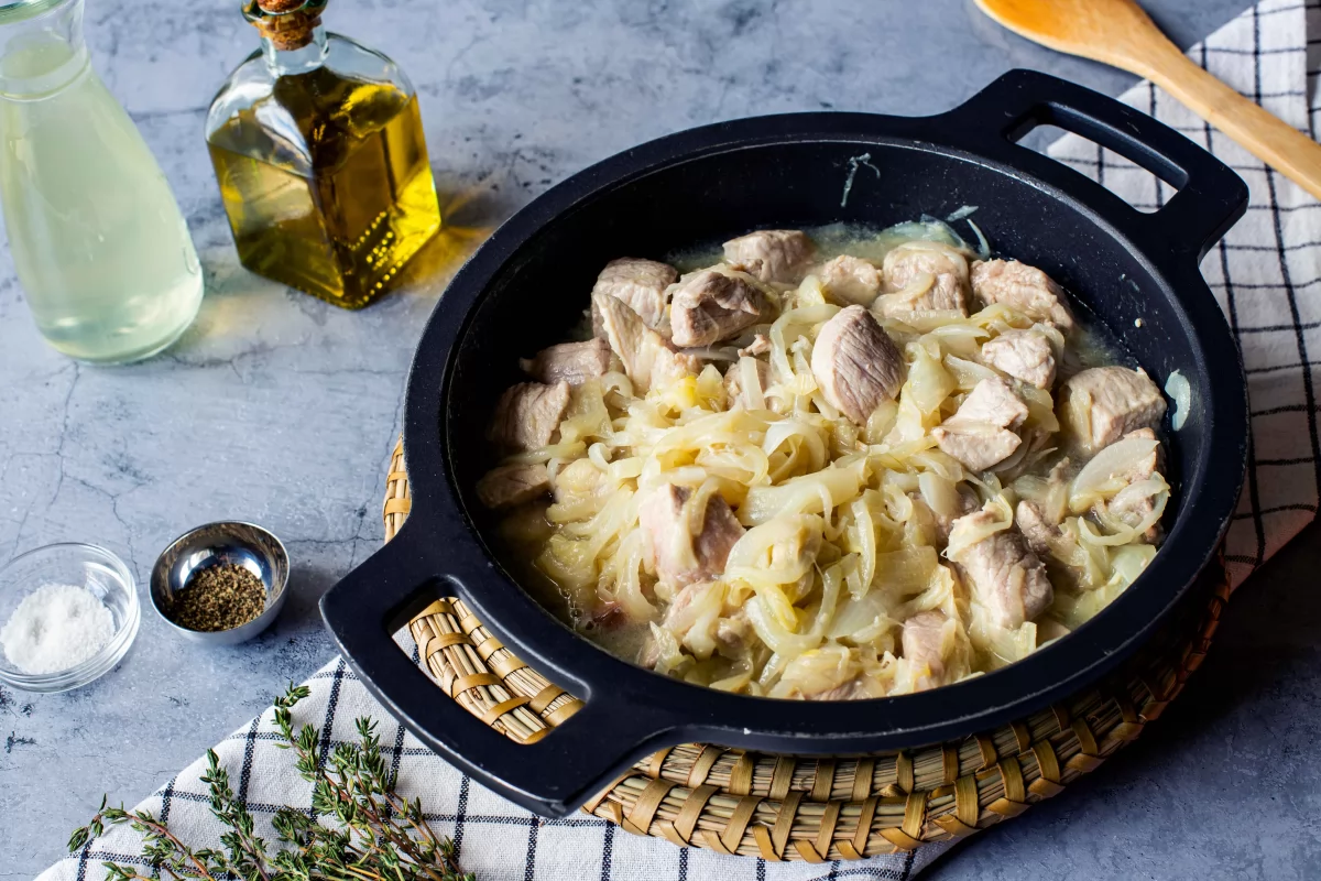Incorporar vino blanco para hacer el cerdo guisado con cebolla *