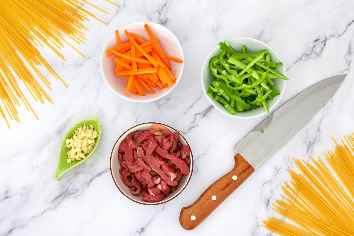 Ingredientes cortados de los tallarines chinos con verduras, carne y gambas