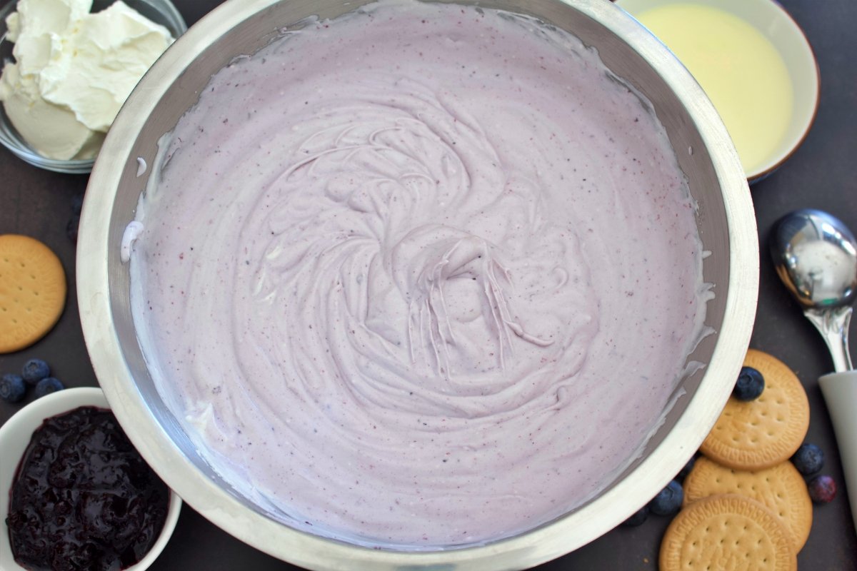 Introduciendo la mermelada de arándanos para seguir haciendo el helado de cheesecake