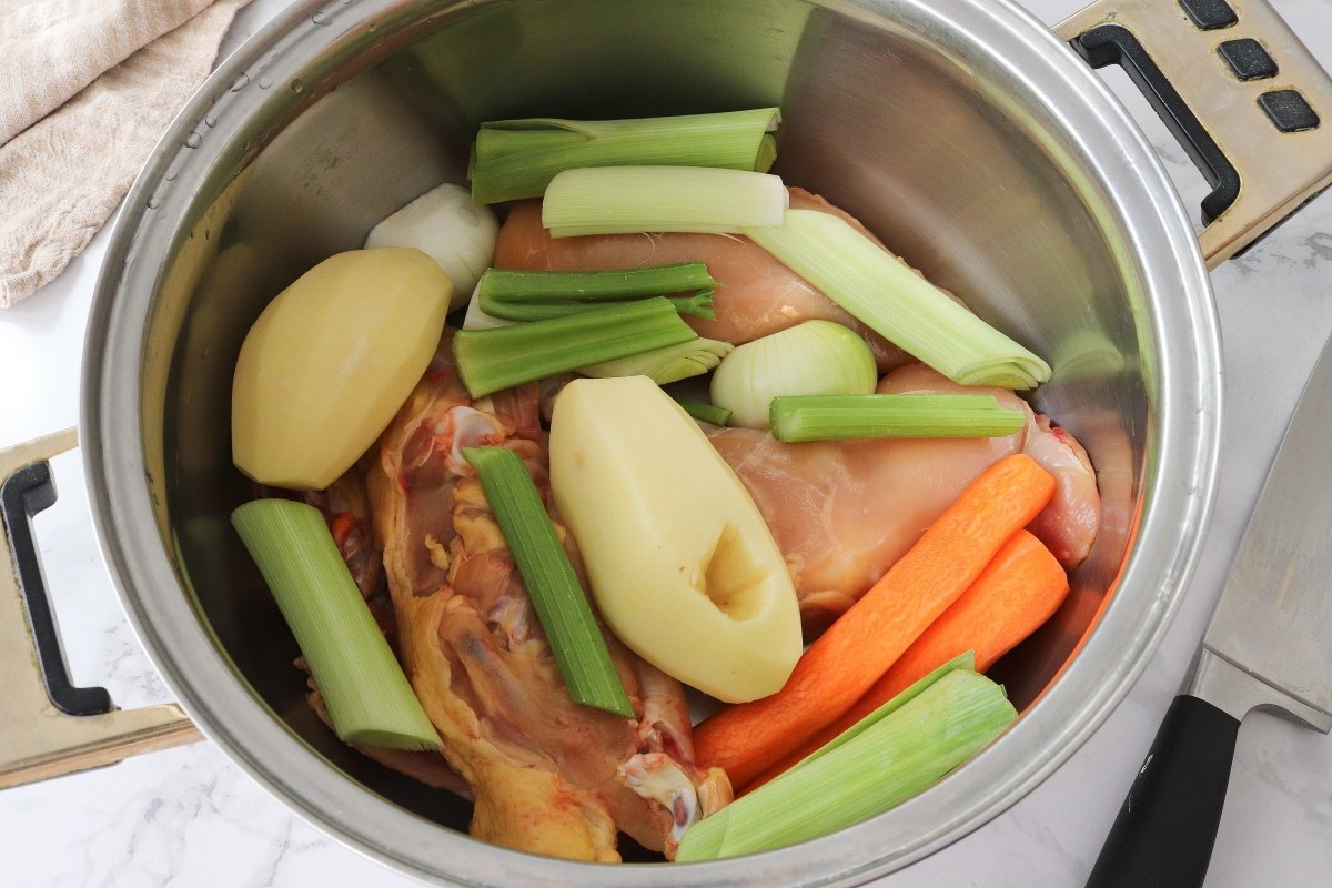Introducir las verduras en la olla para la sopa de pollo