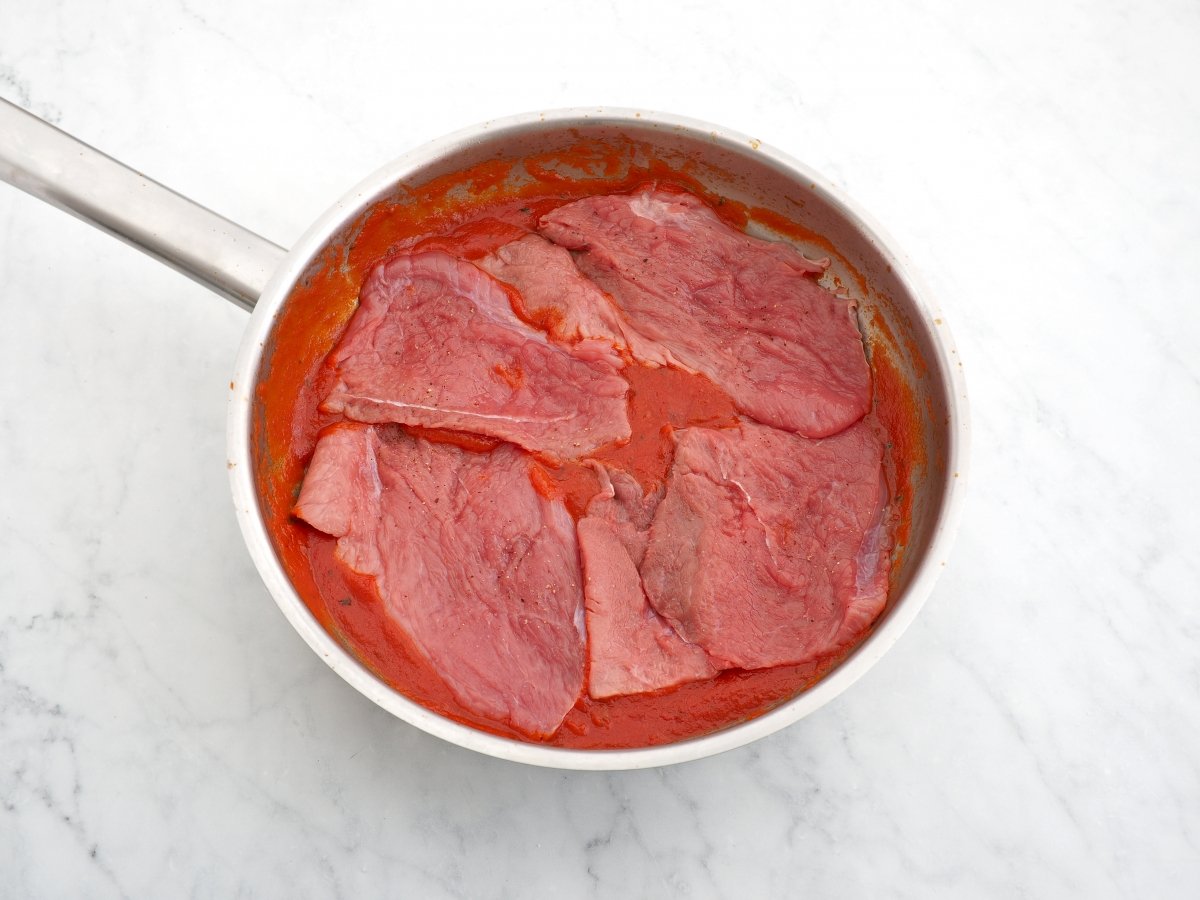 Introducir los filetes en la salsa de tomate