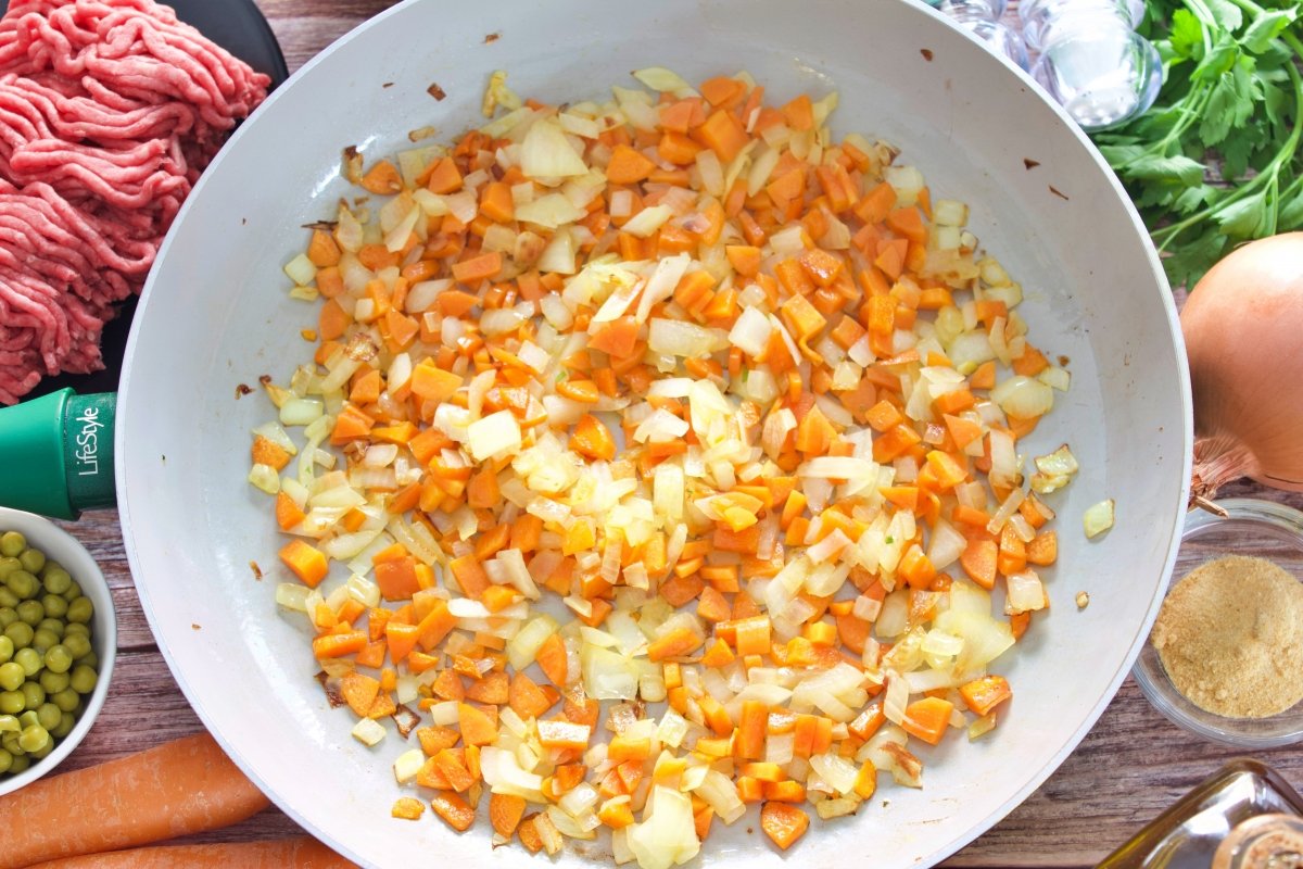 La cebollas y la zanahoria de las albóndigas a la jardinera en una sartén