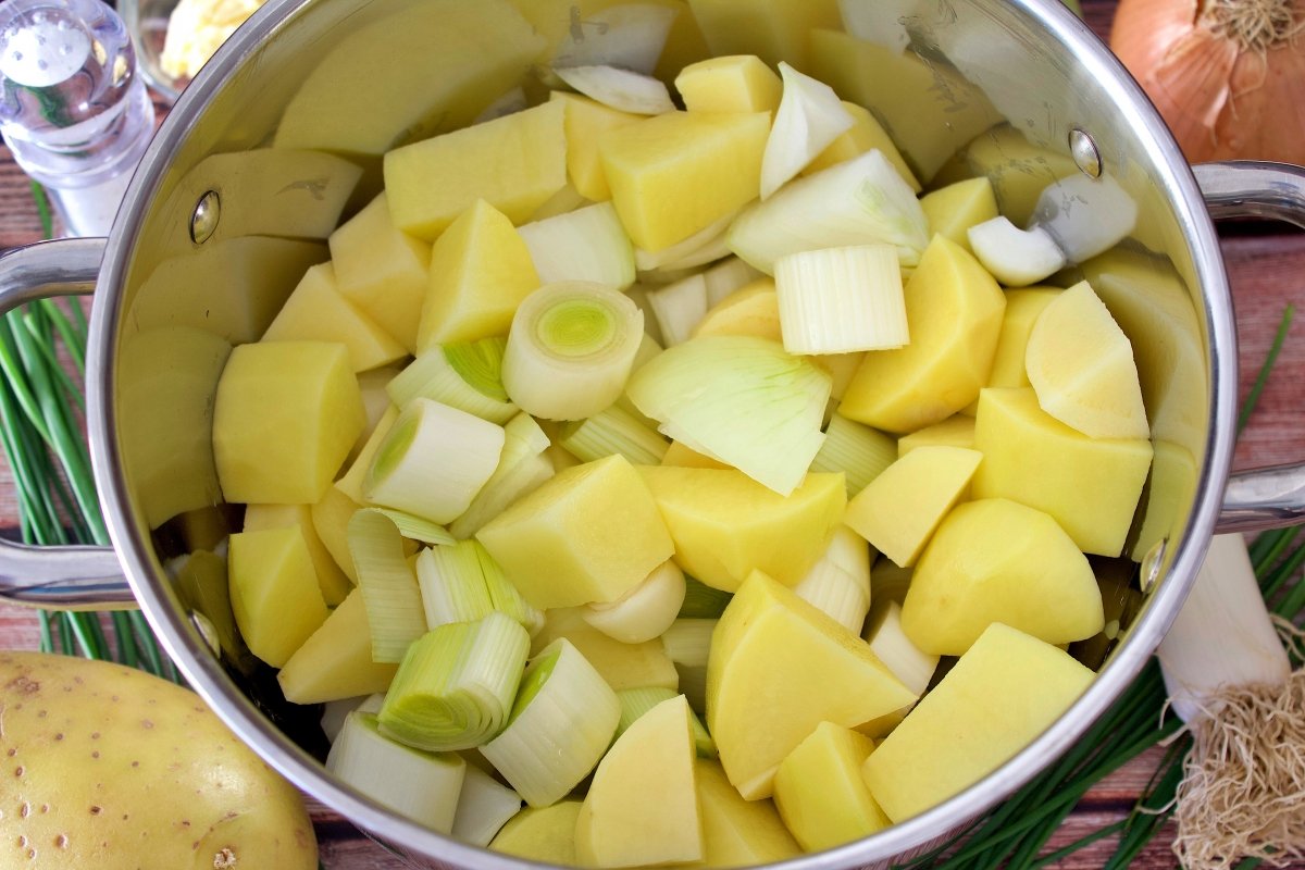 La mantequilla, el aceite, los puerros y las patatas de la vichyssoise tradicional en una olla
