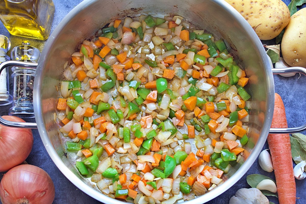 Las cebollas, la zanahoria y el pimiento del jarrete de cordero sofritos en la olla