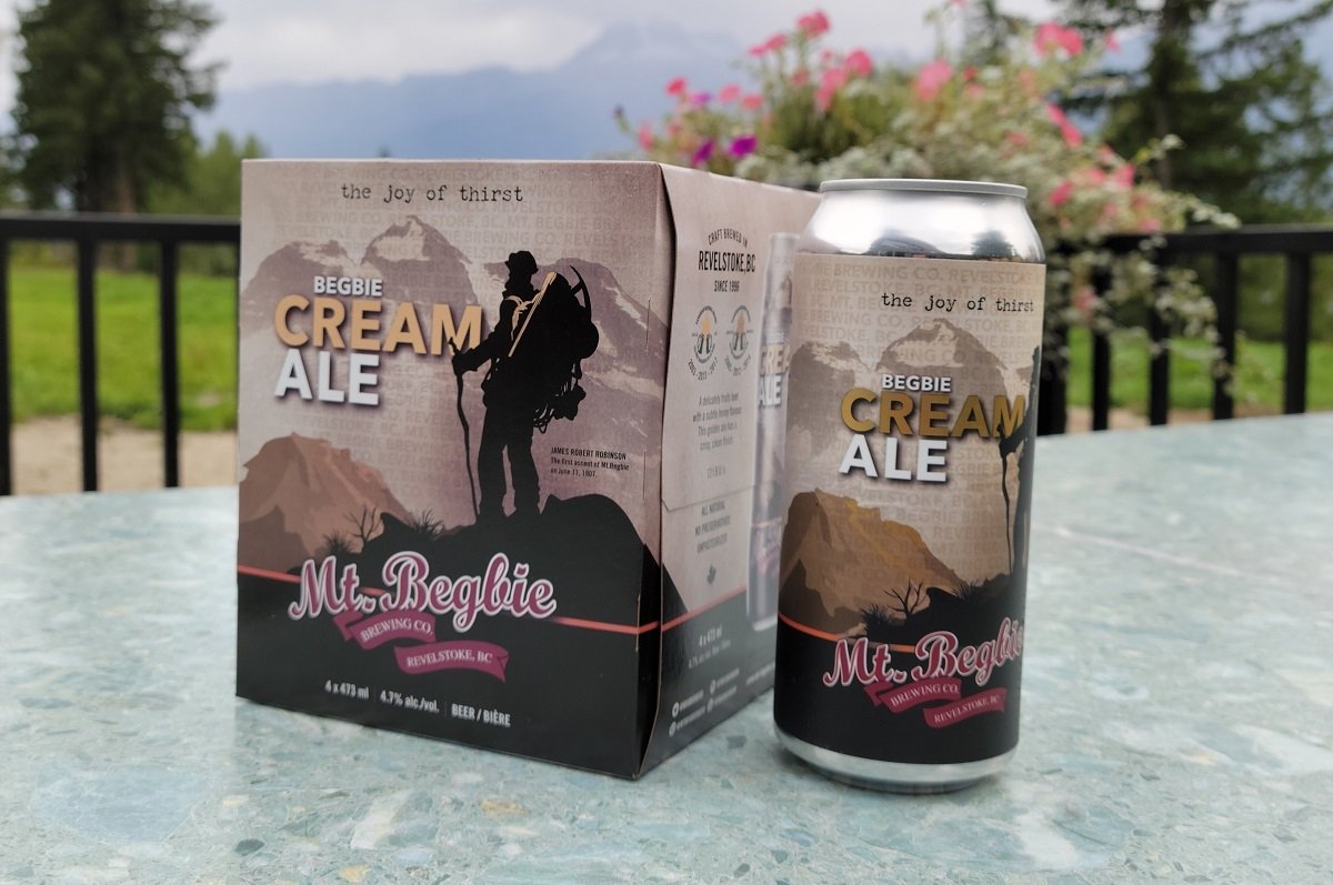 Lata y caja de Mt Begbie Cream Ale con el jardín de fondo
