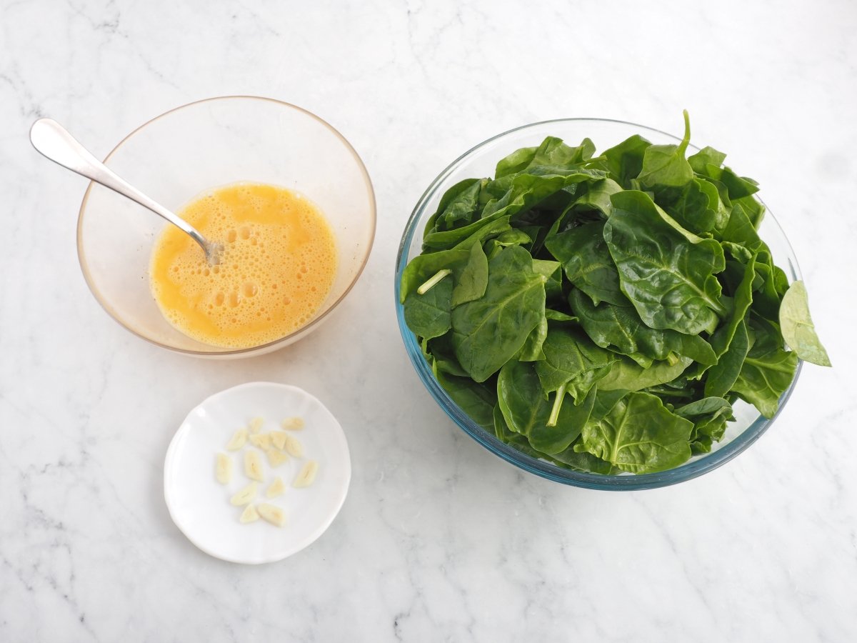 Lavar las espinacas y batir los huevos