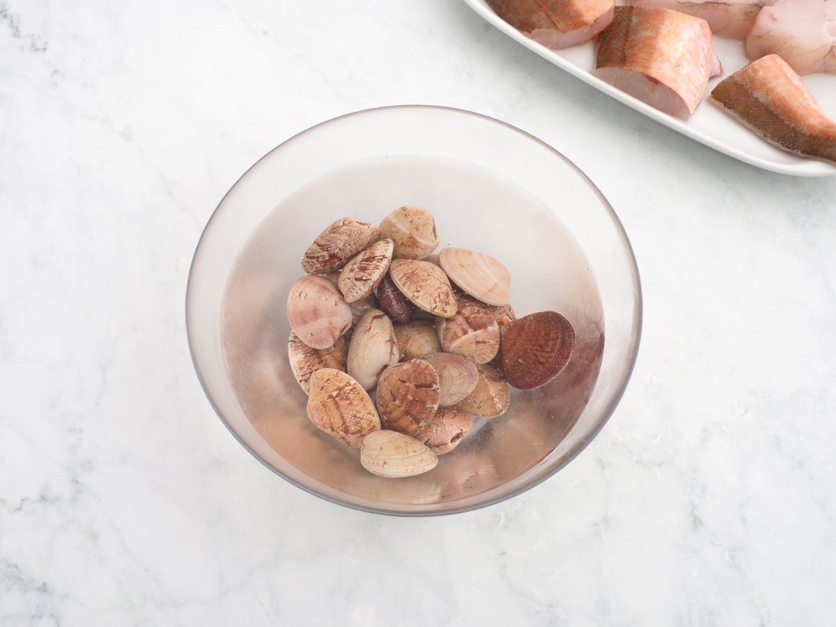 Limpiar las almejas en agua con sal para la cazuela de pescado