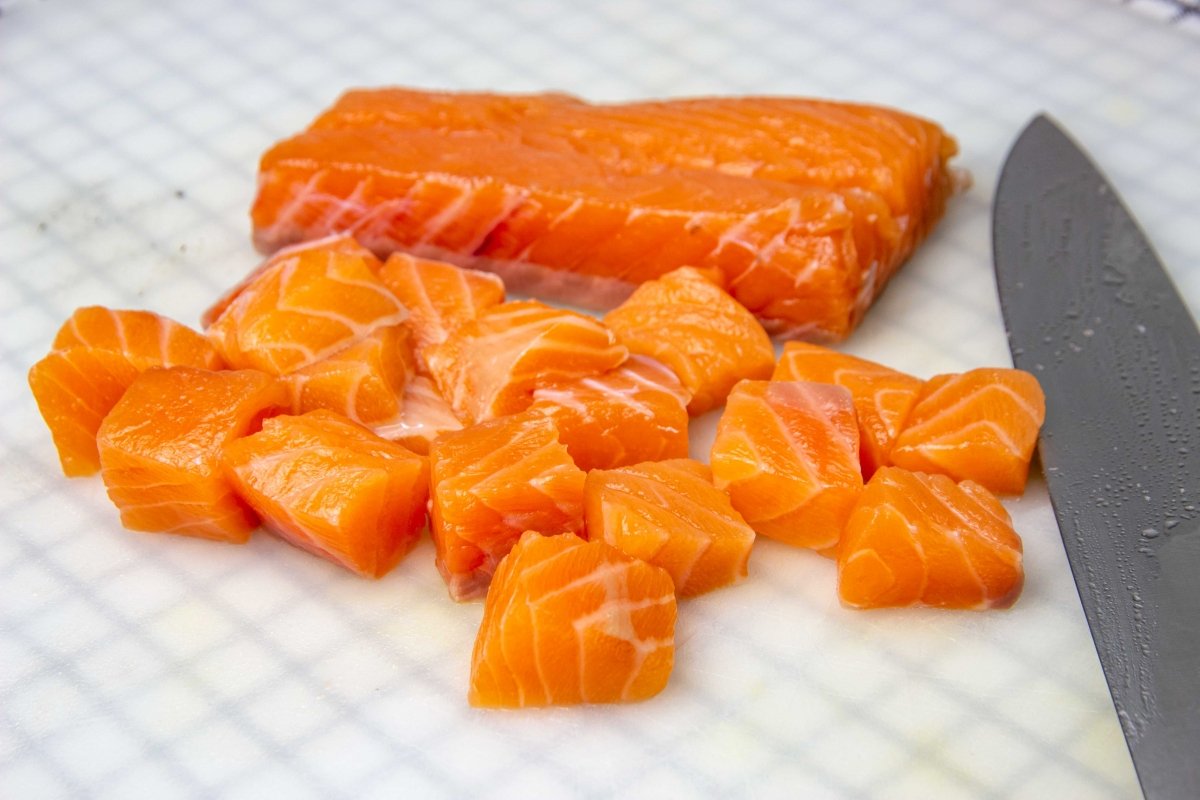 Limpiar y cortar salmón en dados para la ensalada