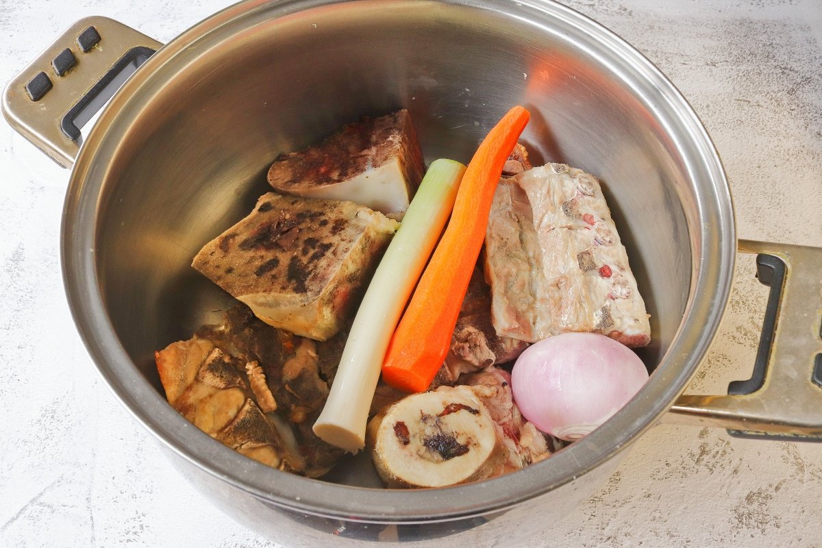 Llevar los huesos y las verduras a la olla para hacer el caldo