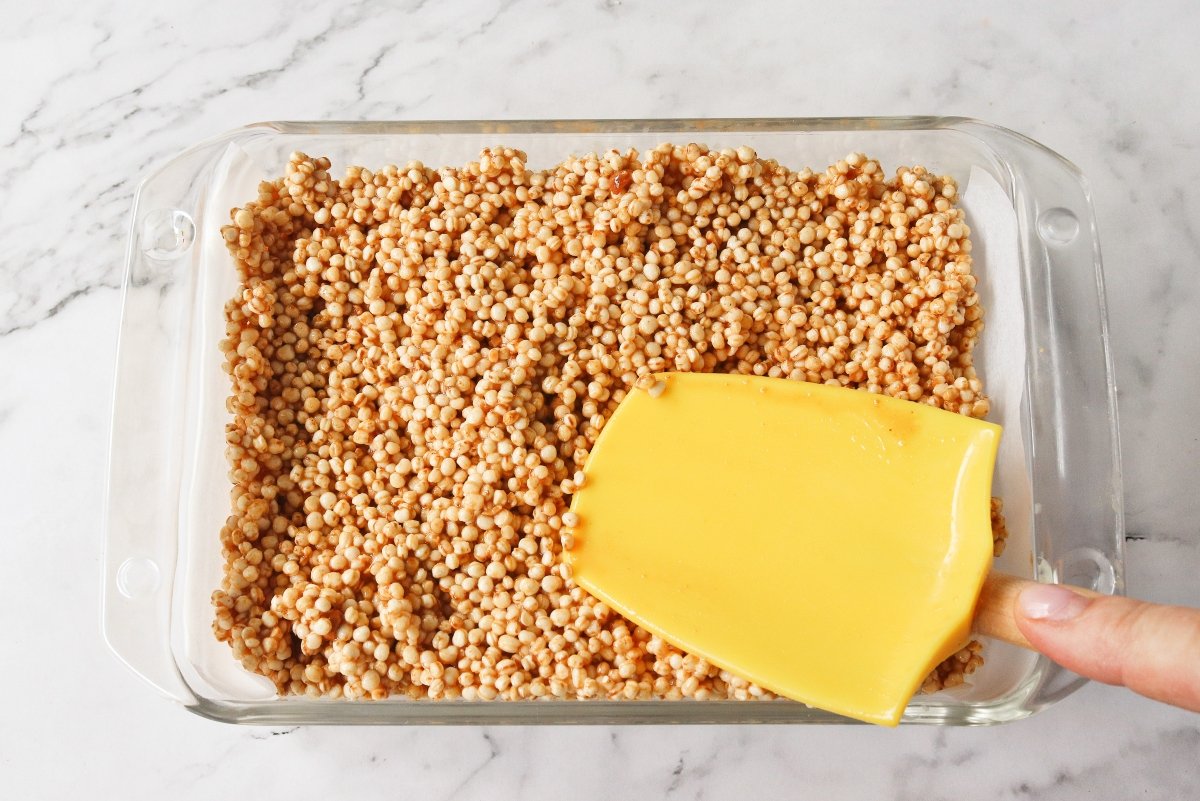 Llevar los ingredientes de las barritas de quinoa inflada a un molde