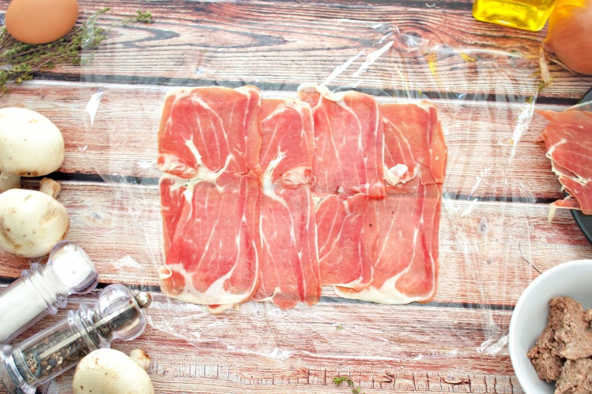 Lonchas de jamón serrano sobre papel film para hacer el solomillo de cerdo Wellington con hojaldre