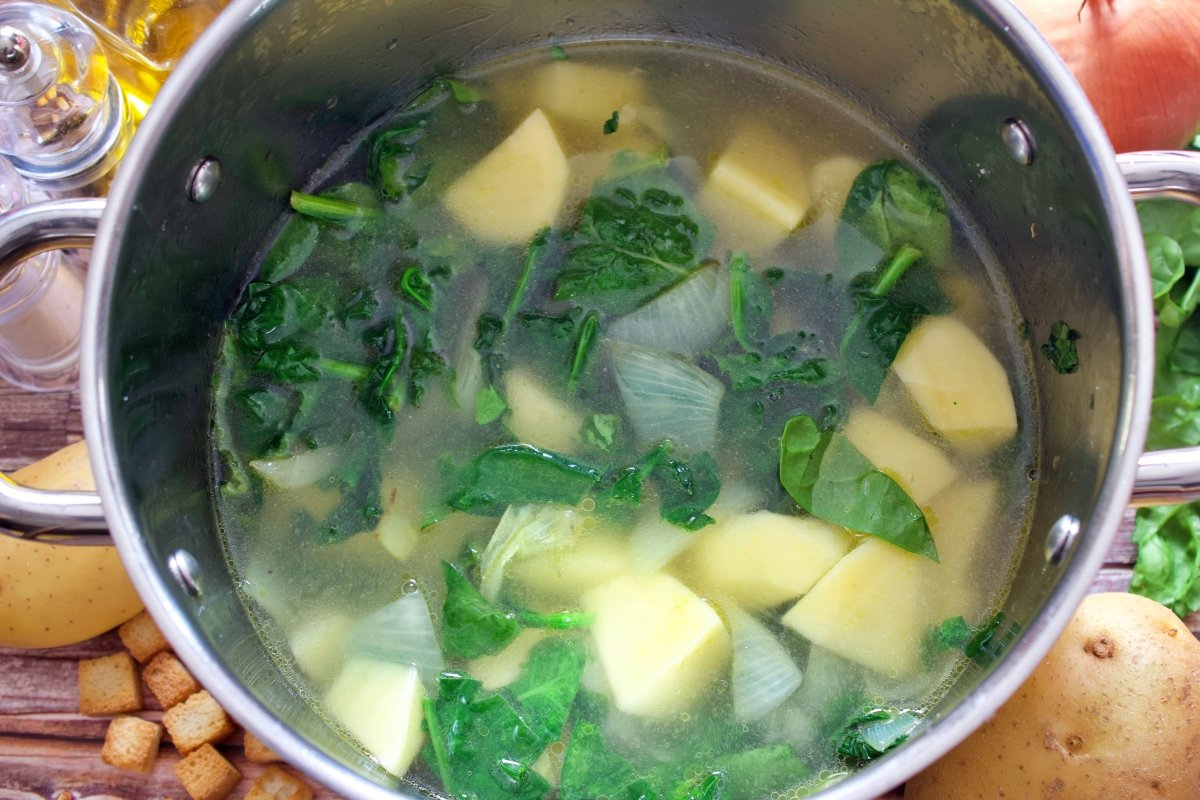 Los ingredientes del puré de espinacas cubiertos de agua en una olla