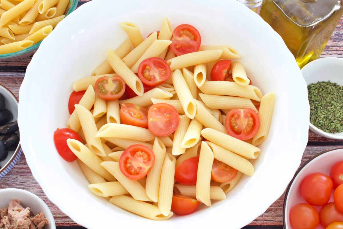 Los macarrones y los tomate cherri de la ensalada de macarrones fría mezclados