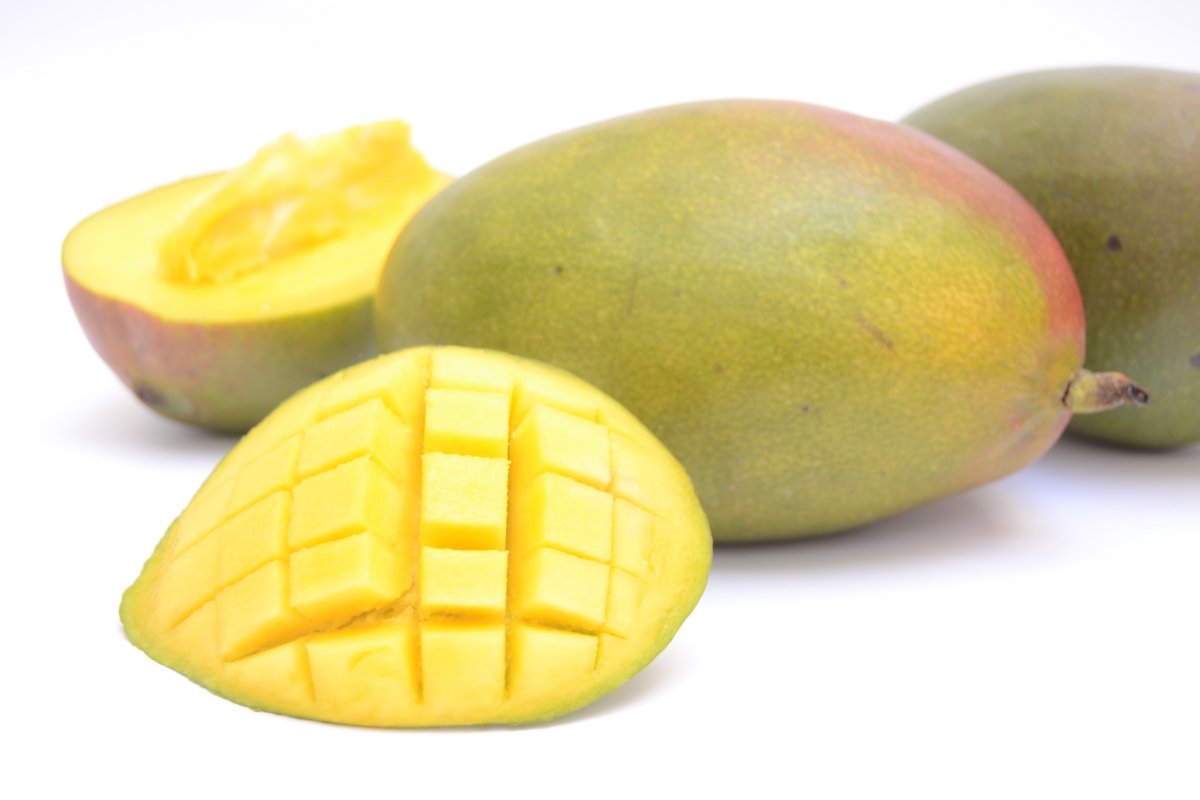 Mangos enteros y abiertos con su pulpa amarilla a la vista