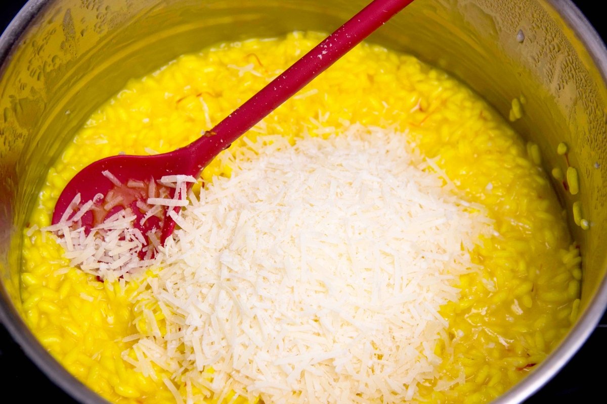 Mantecar el risotto alla milanese con el queso parmesano