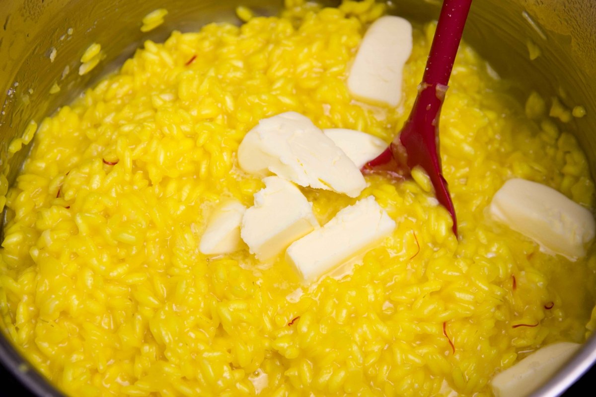 Mantecar el risotto alla milanese con la mantequilla restante