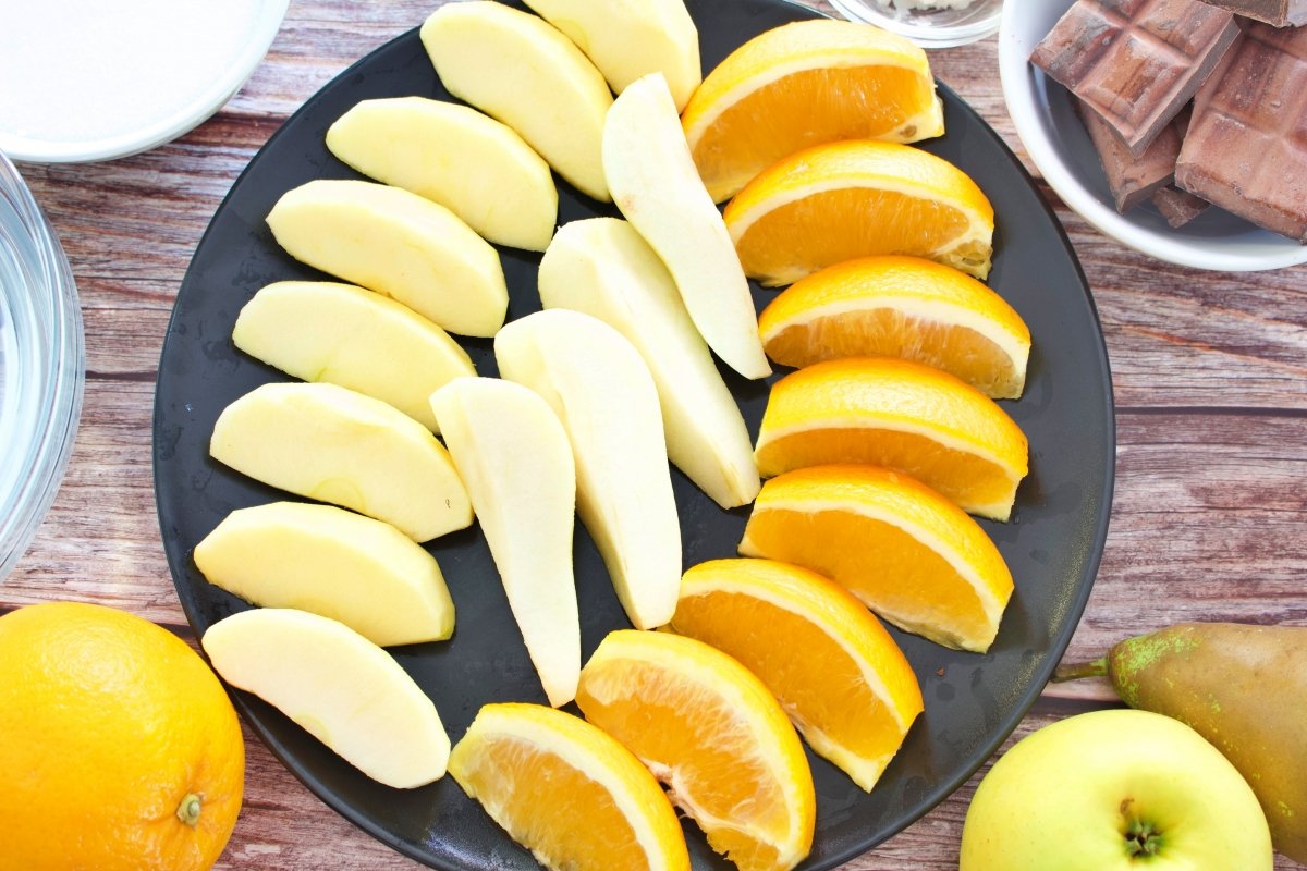 Manzana, pera y naranja cortadas en un plato para las frutas de Aragón