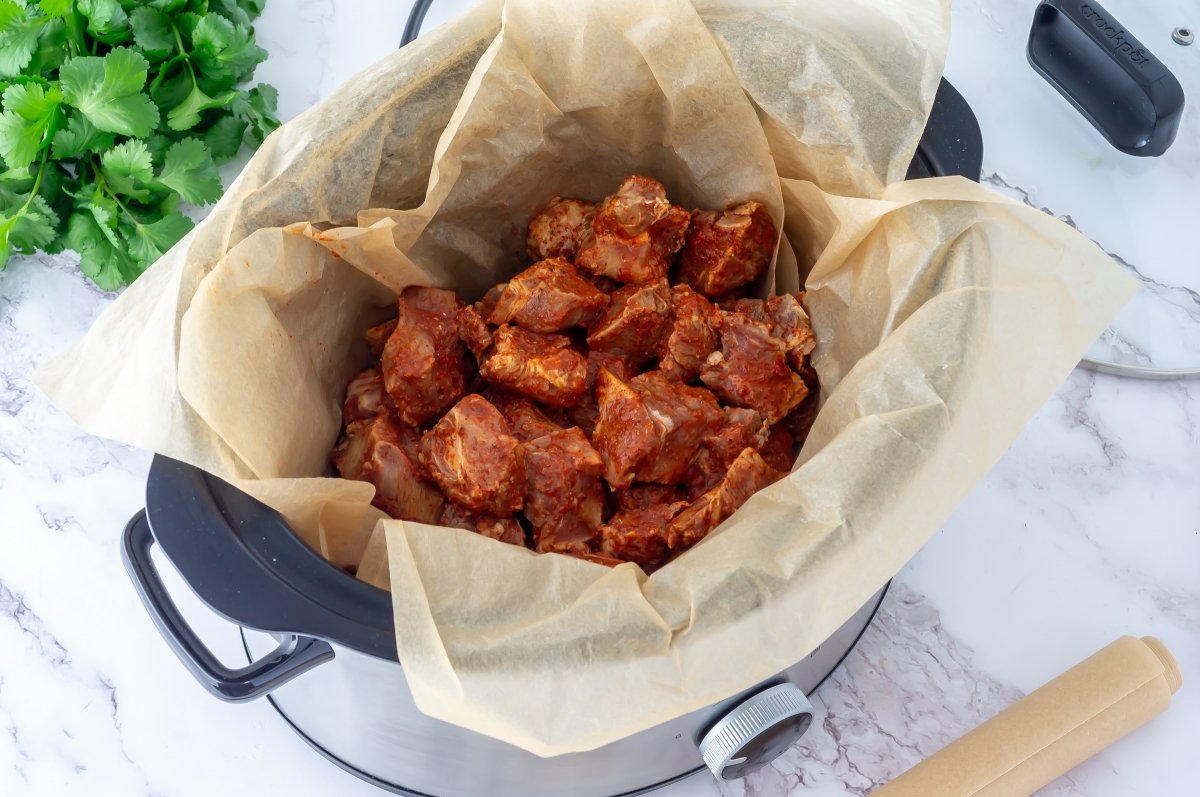Meter la carne en la olla para hacer cochinita pibil en Crock Pot