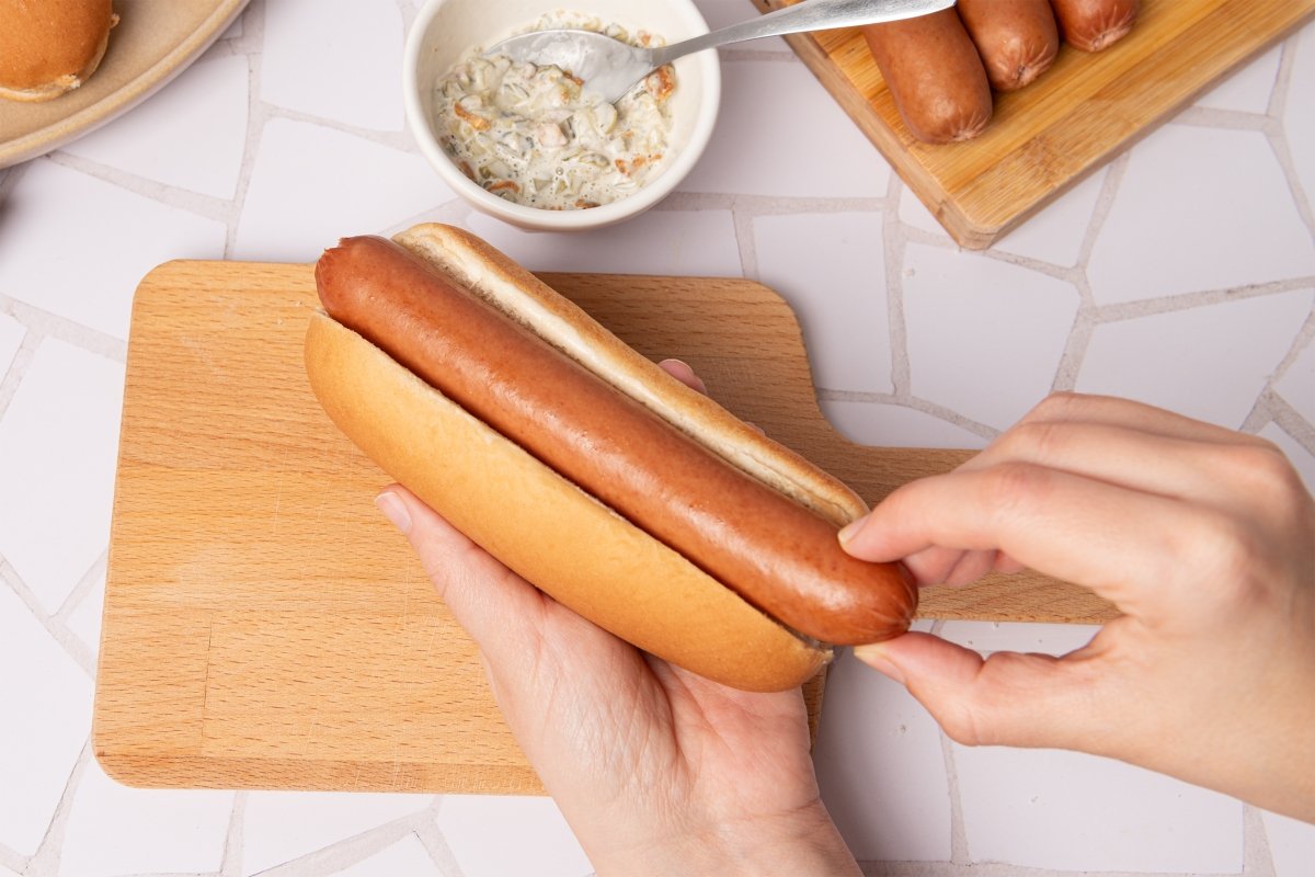 Metiendo la salchicha en el pan de hot dog