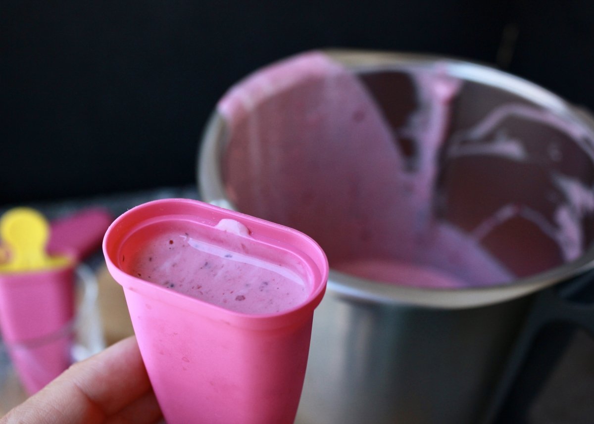 Mixture of the Greek yogurt and red fruit popsicles introduced into the molds