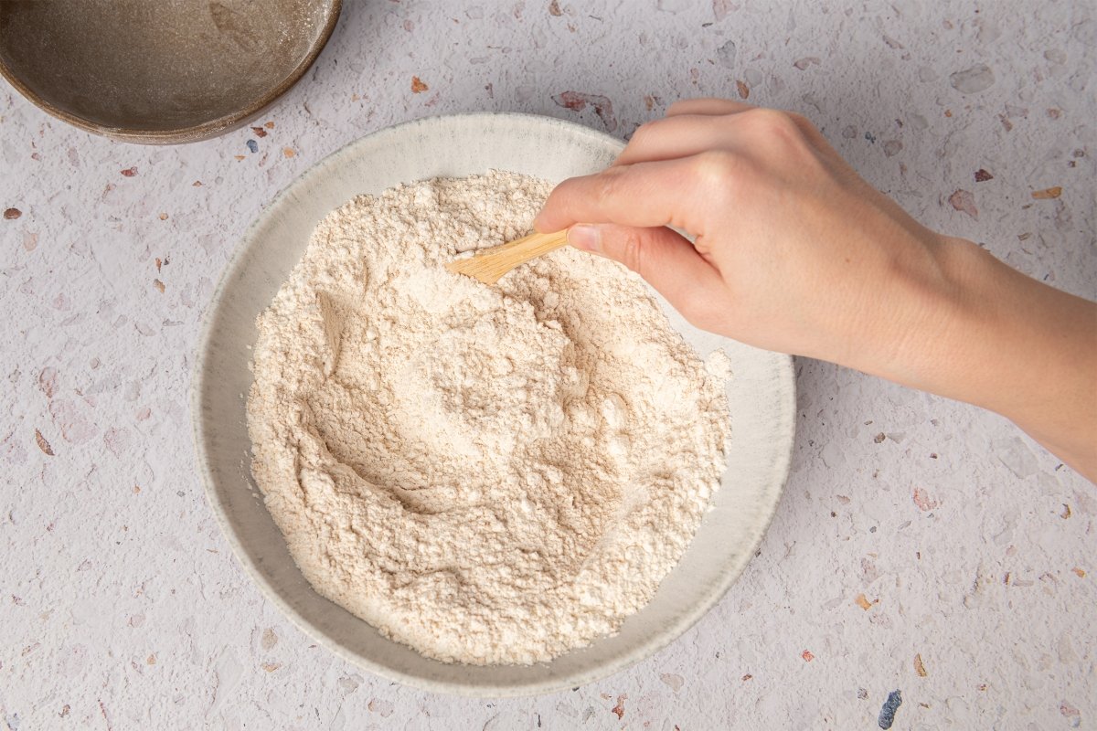 Mezclando harina con sal para hacer pan chapati