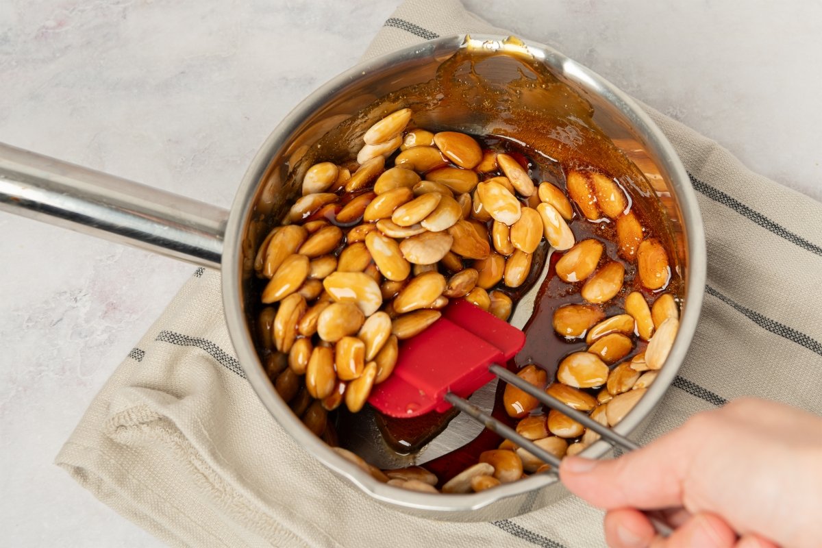 Mezclando las almendras en el caramelo del turrón de guirlache