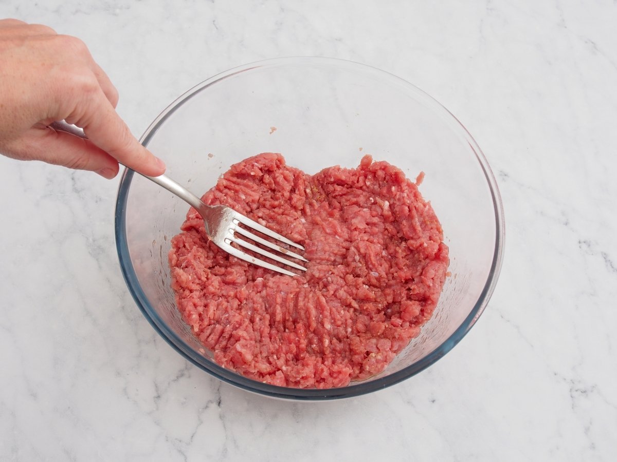 Mezclar con un tenedor la masa de la hamburguesa de carne de ternera casera