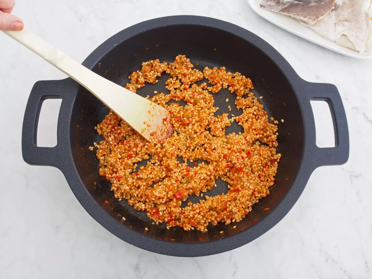 Mezclar el arroz con el sofrito del arroz con bacalao