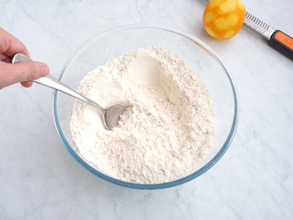 Mezclar la harina con el azúcar y la ralladura de naranja