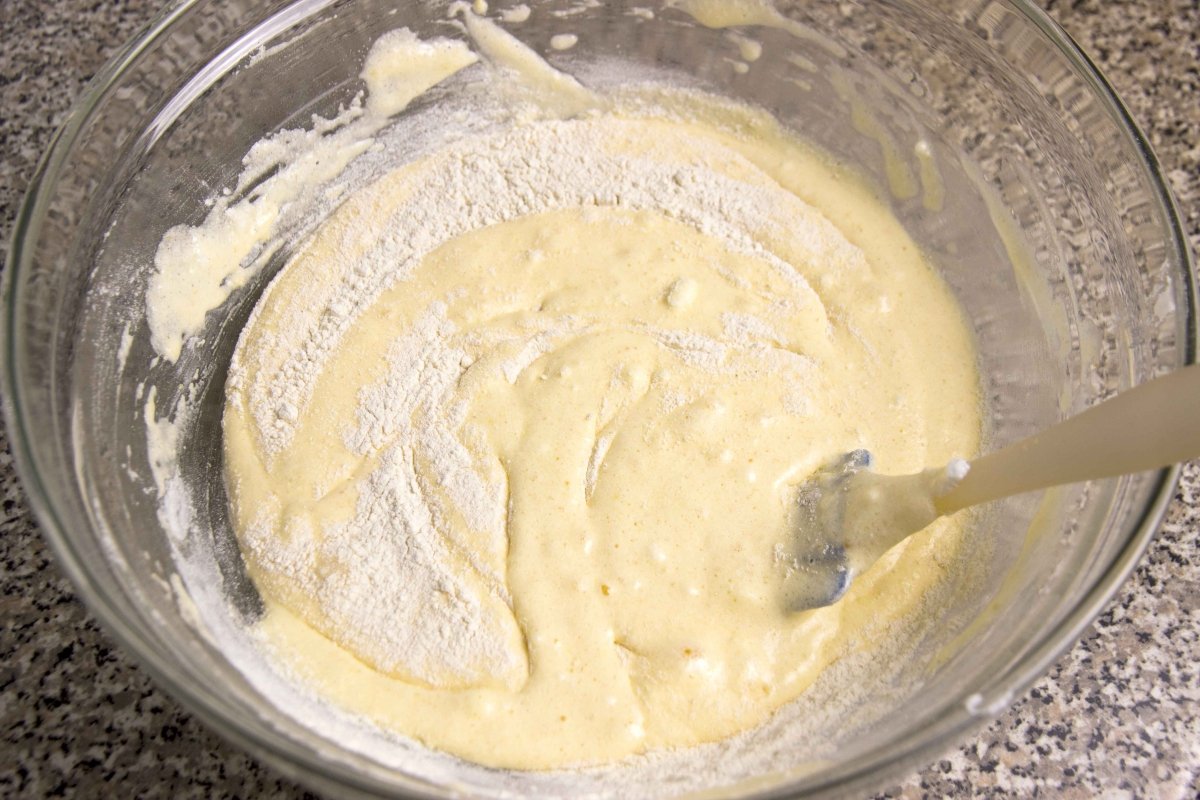 Misture a farinha peneirada e o fermento de forma envolvente para fazer o bolo
