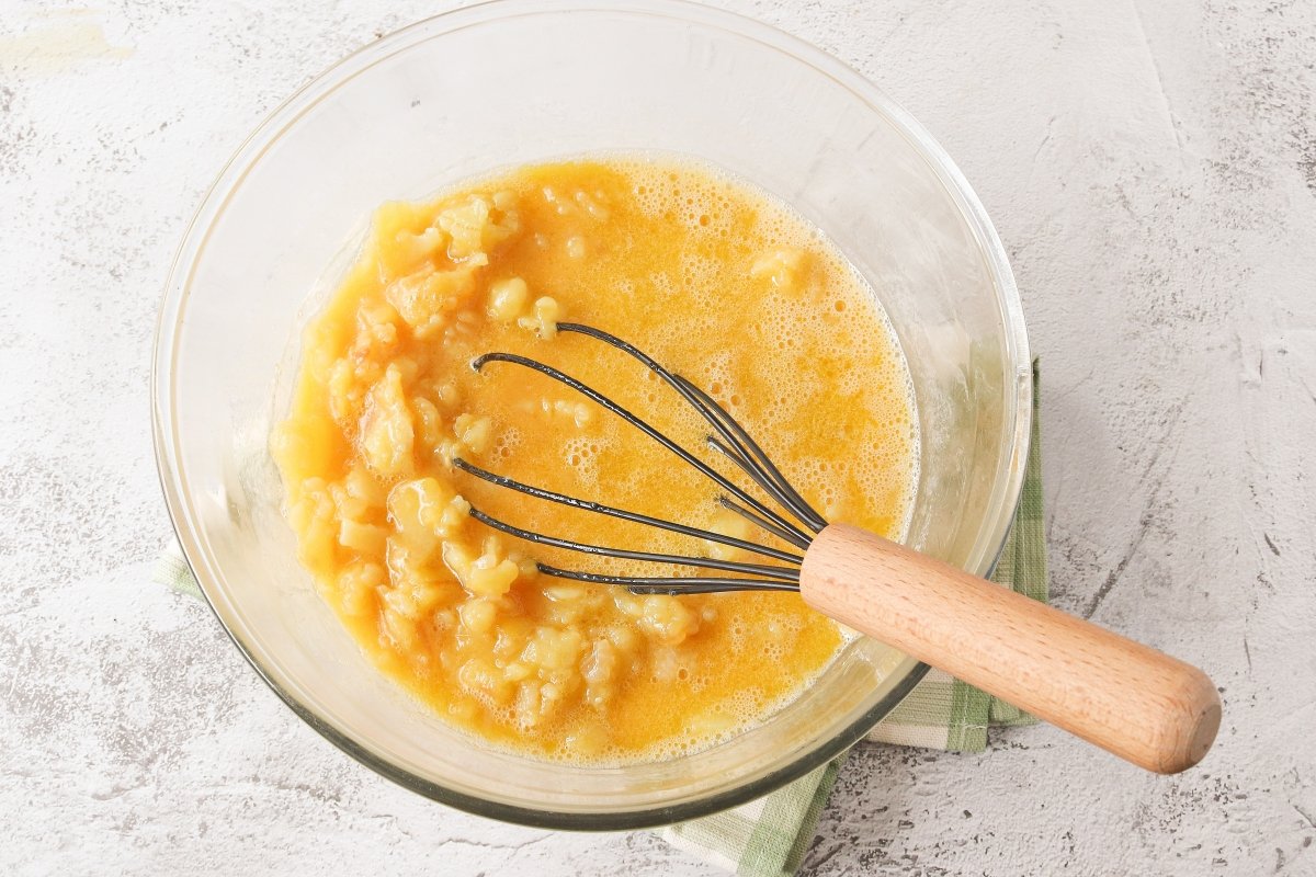 Mezclar la patata y el huevo para la tortilla rellena de jamón y queso