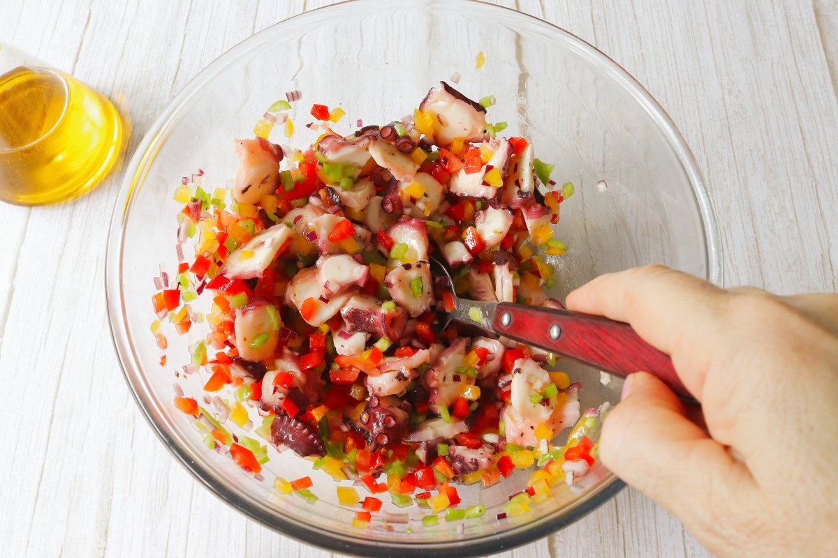 Mezclar la vinagreta en la ensalada de pulpo