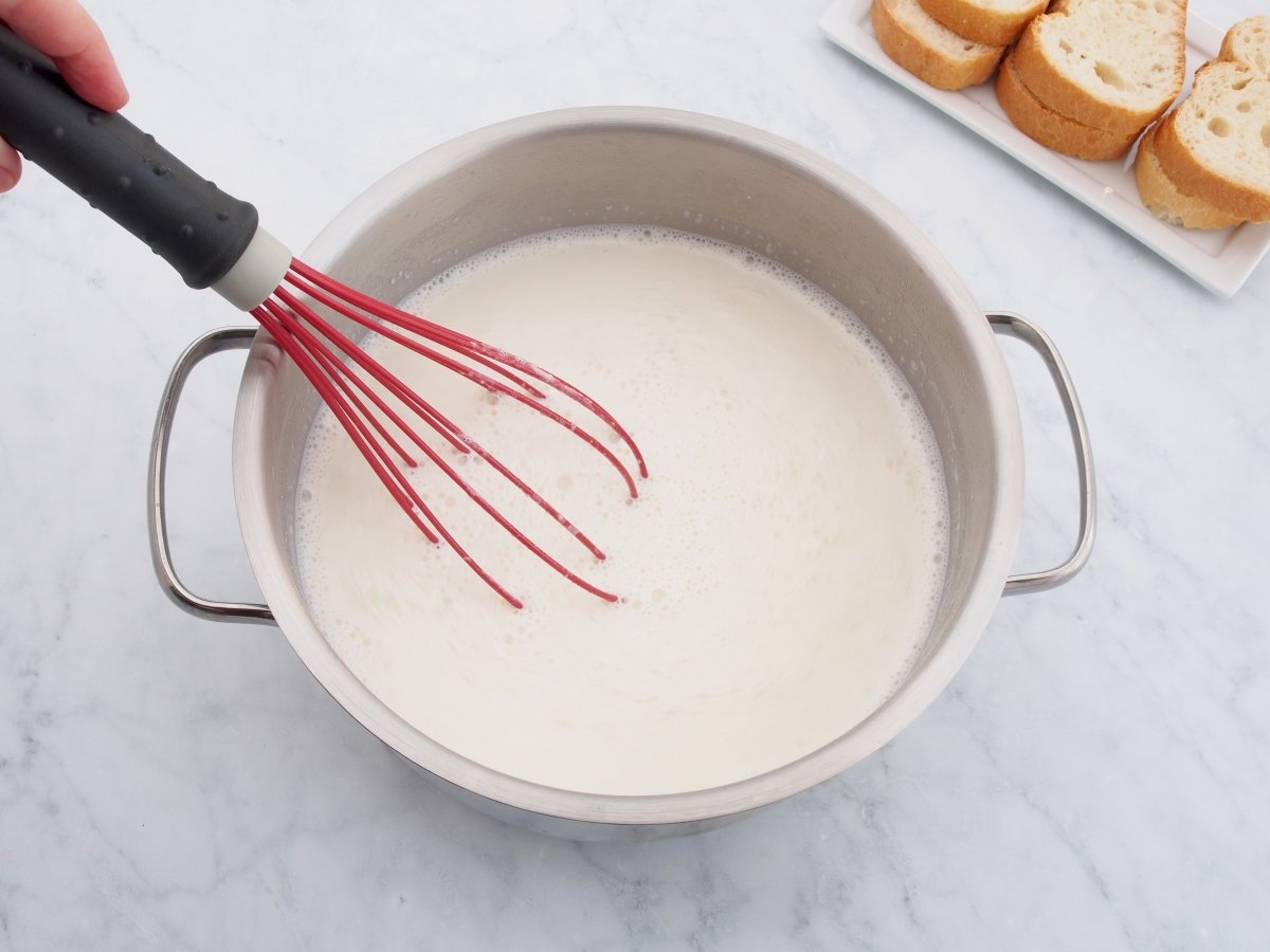 Mezclar para disolver la pasta de almendras en la leche para la sopa de almendras