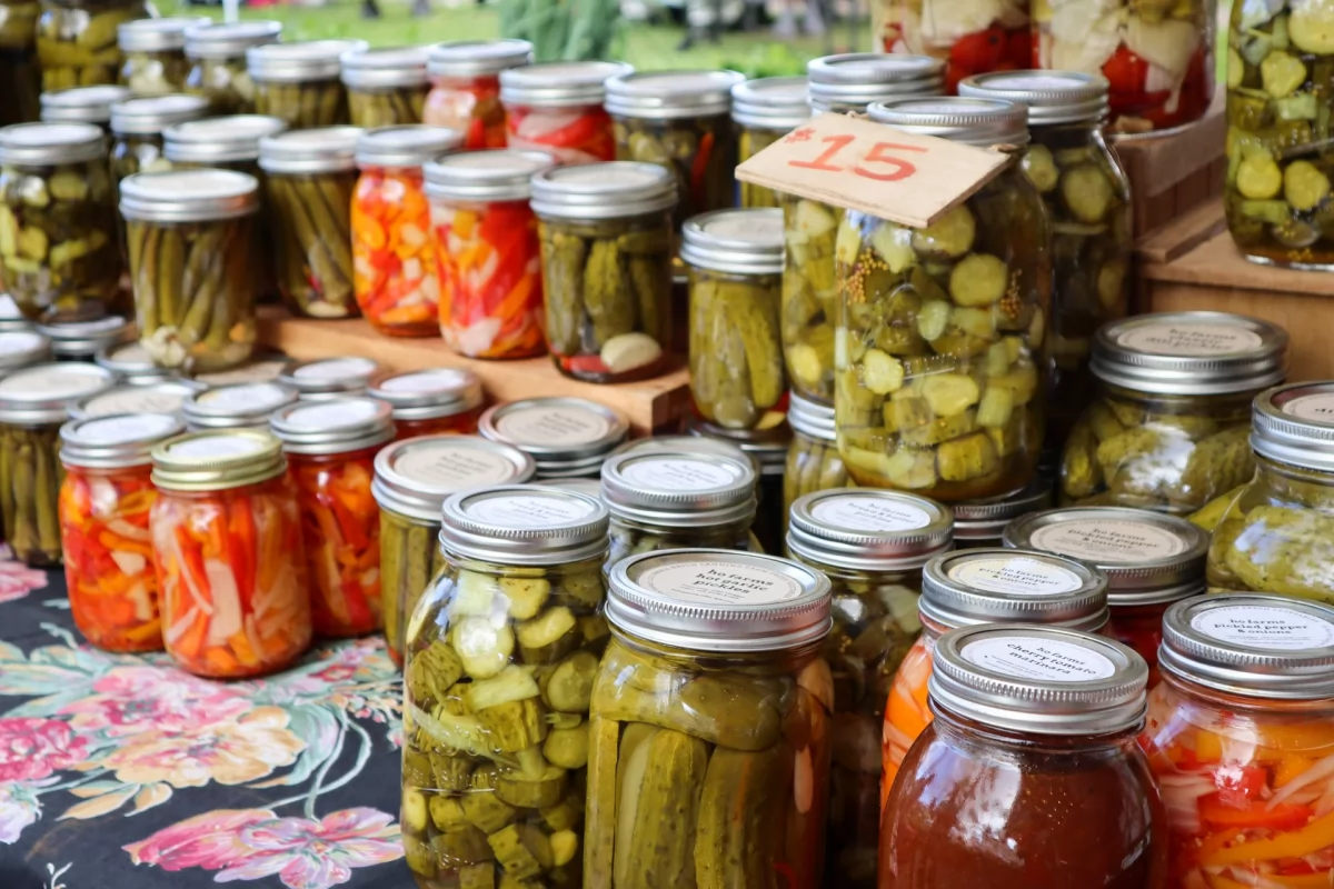 Muchos botes de cristal con verduras y hortalizas encurtidas