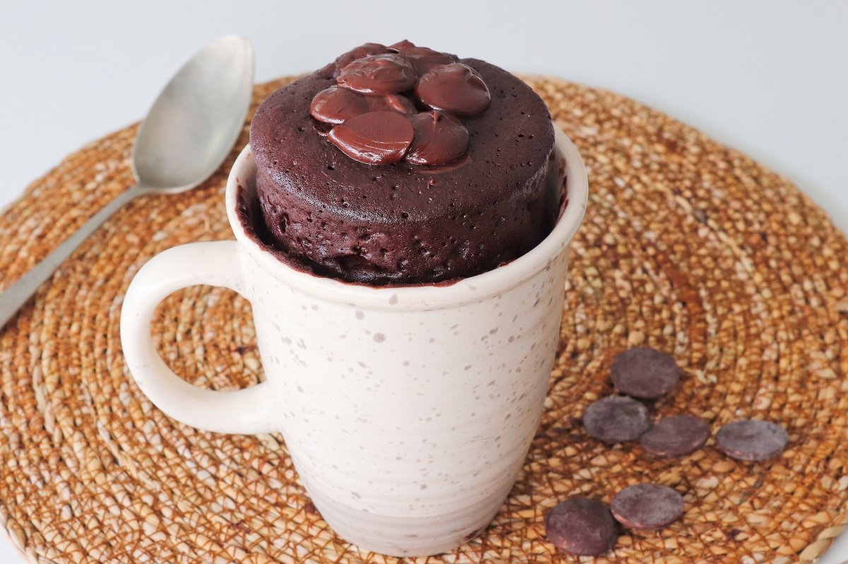 Chocolate mug cake in microwave close up photo