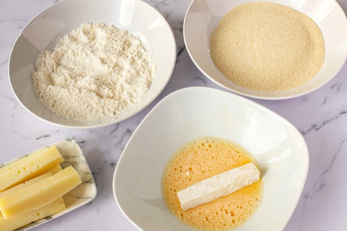 Pasar el queso por huevo batido para hacer kushiage de queso