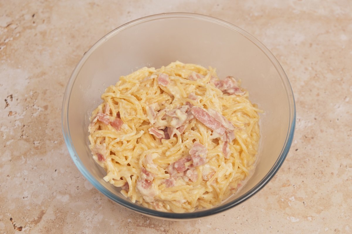 Pasar la pasta con la salsa carbonara a un bol grande