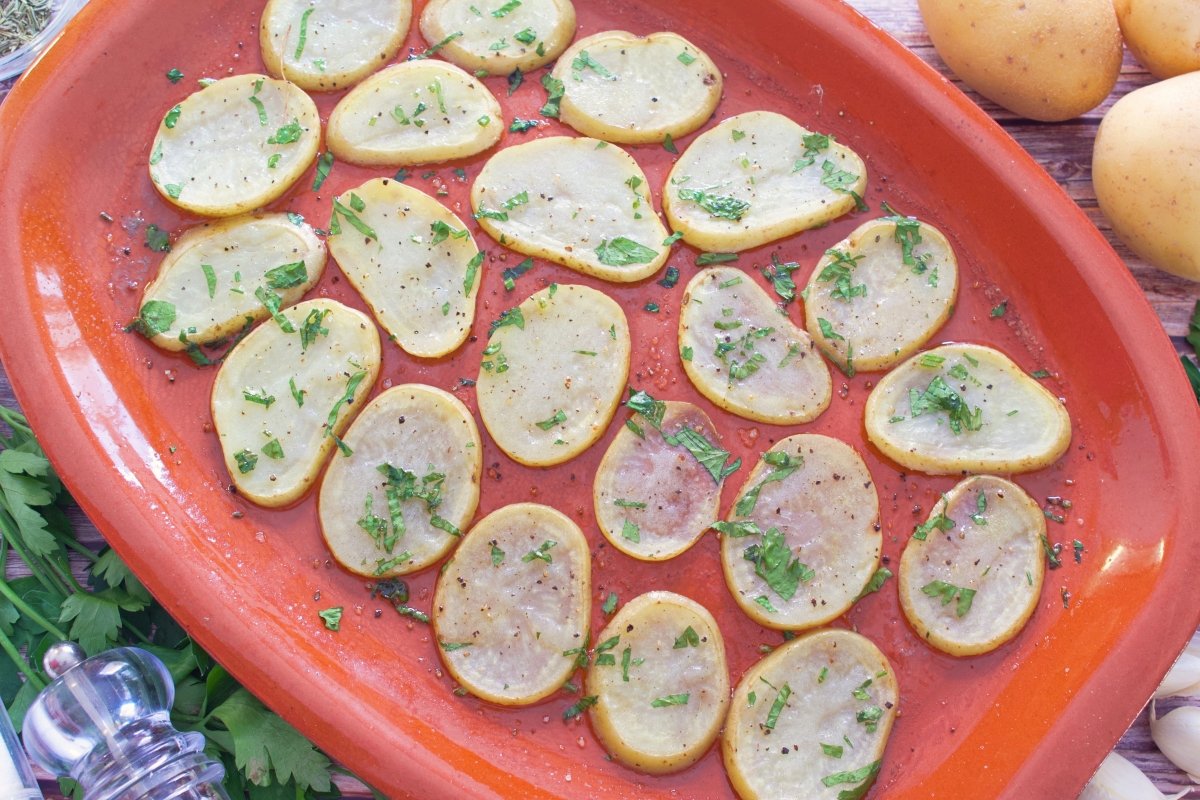 Patatas sobre una bandeja de horno para el ternasco asado con patatas
