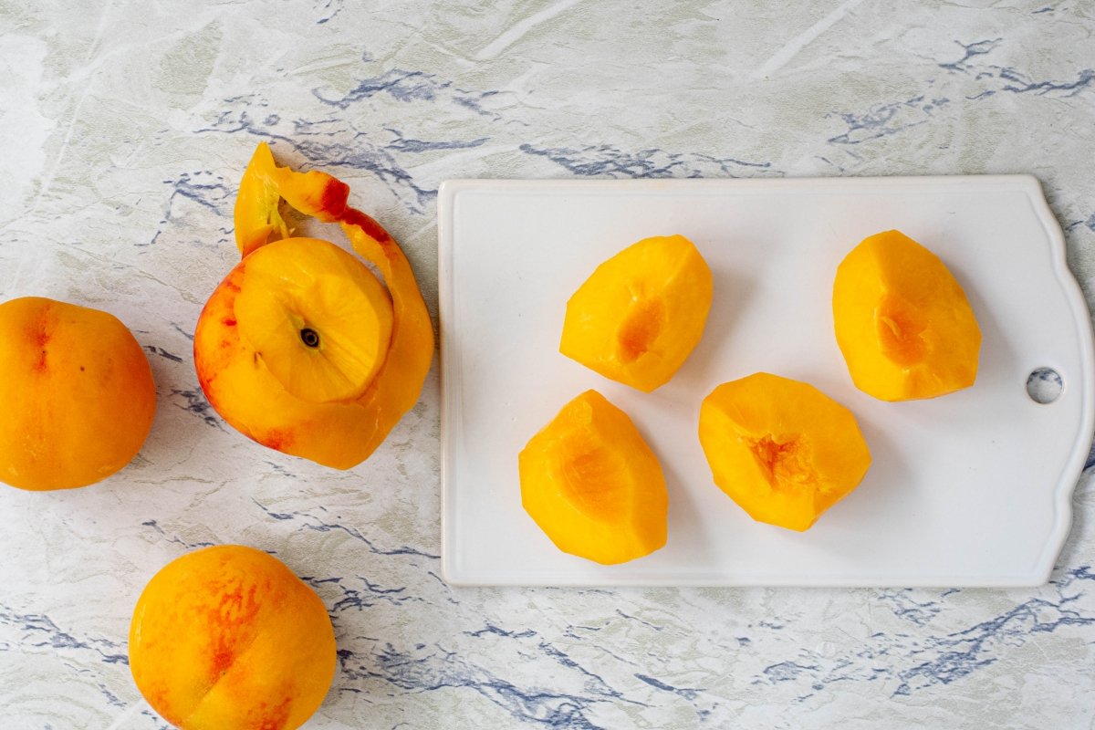Peel and cut the peaches for the peach tarte tatin
