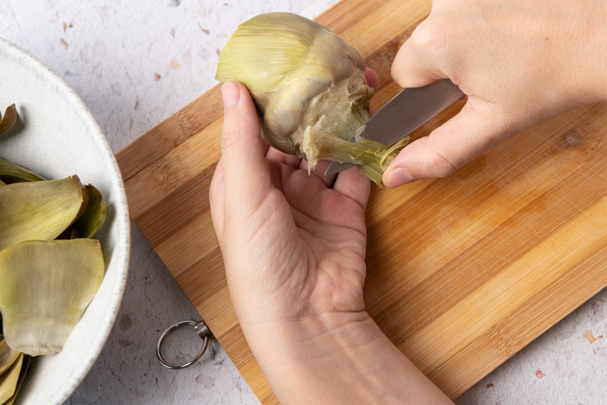 Pelando el tallo de una alcachofa para hacer alcachofas a la plancha