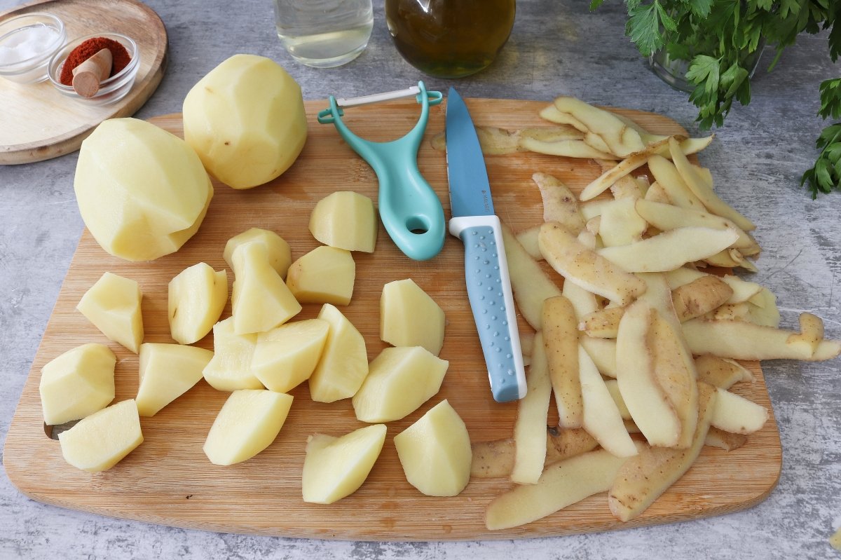Pelar y cortar patatas guiso de merluza con patatas