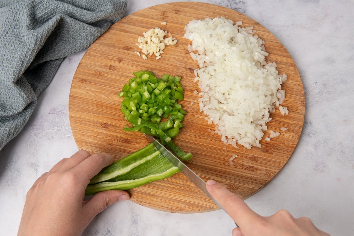 Picando hortalizas para el sofrito de las alubias con almejas